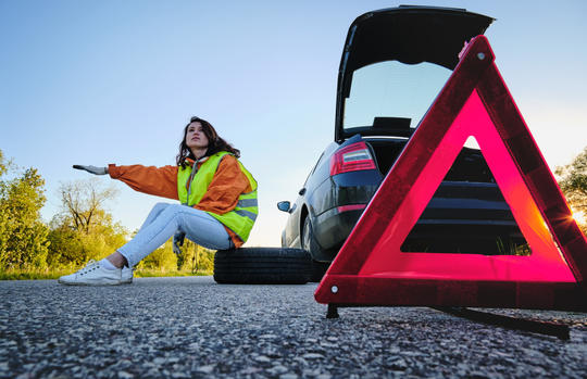 woman-changes-the-damaged-wheel-of-the-car